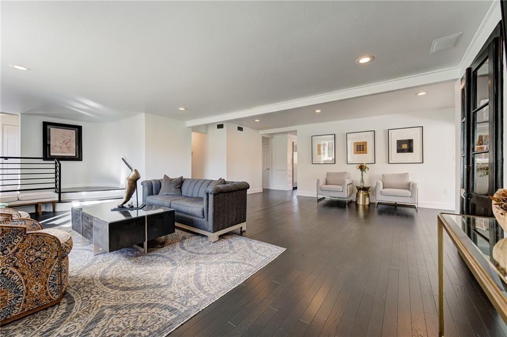 An open great room staged with a sofa, art and accent chairs, ready for buyer showings