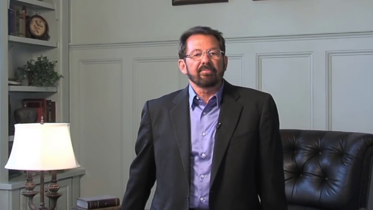 A Showhomes presenter speaking to camera in a book-lined study